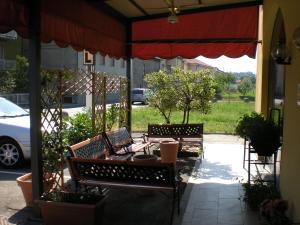 奥莱焦马尔彭萨埃尔酒店的庭院设有2个长椅和红色遮阳伞