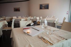 卡斯泰尔菲达尔多克拉斯酒店的用餐室配有带白色桌布和玻璃杯的桌子