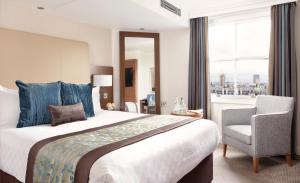 伦敦Thistle London Piccadilly的酒店的客房 - 带一张床、椅子和窗户