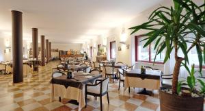 巴多利诺Veronello Resort的一间设有桌椅和盆栽的餐厅