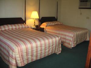 洛克波特洛克波特套房酒店的酒店客房,设有两张床和一盏灯