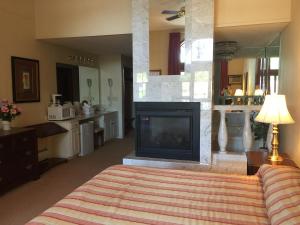 洛克波特洛克波特套房酒店的一间卧室设有壁炉和带电视的床铺。