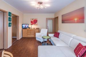 奥斯赛拜-屈隆斯博恩Am Weststrand Apartmenthaus Bellamare的客厅配有白色沙发和电视