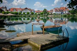 NiedernbergSeehotel Niedernberg - Das Dorf am See的水面上的小船码头