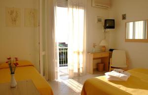 马里纳-迪-皮特拉桑塔阿尔克酒店的一间卧室设有两张床、一张桌子和一个窗口。