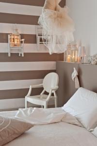 葛伦坦马勒罗马酒店的一间卧室设有条纹墙、一张床和一把椅子
