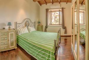 布拉恰诺卡萨莱普拉托特拉度假屋的一间卧室配有一张带绿色棉被的床