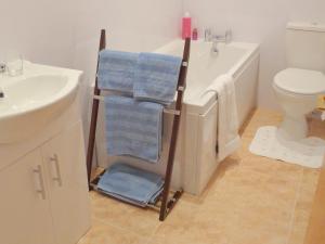 SulbyBallacowell Cottage的浴室配有浴缸旁的毛巾架