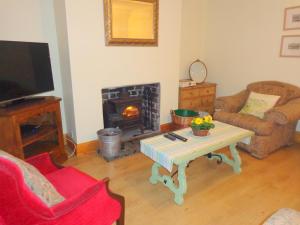 SulbyBallacowell Cottage的客厅配有咖啡桌和壁炉
