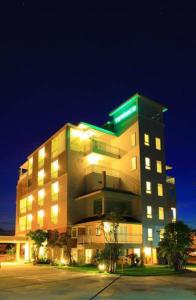 洛坤府露台酒店的一座在晚上拥有绿色屋顶的大型建筑