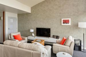 罗斯福尔斯塔马尔河公寓的客厅配有2张沙发和1台平面电视