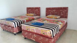 庞岸达兰竹楼酒店的两张睡床彼此相邻,位于一个房间里