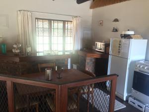 安德伯格Lairds Lodge的厨房配有桌子和冰箱