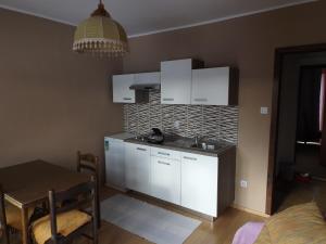 科尔尼鲁格Guest House Raukar的一间厨房,内设白色橱柜和一张桌子