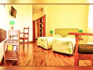 马哈赞加马任加可可酒店及餐厅的卧室配有1张床、1张桌子和1把椅子