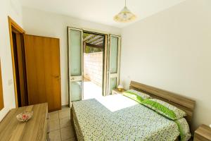 托雷苏达Complesso Gardencasa的一间卧室配有一张床、一张桌子和一个窗户。