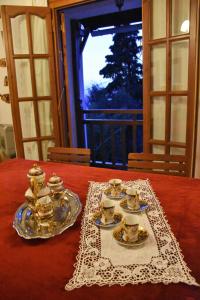 波尔塔里亚Anna's Villa Portaria的桌子上带盘子和杯子的桌子