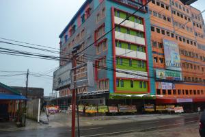 邦加槟港Puncak Budget Hotel的城市街道上一座高大的建筑,窗户色彩缤纷
