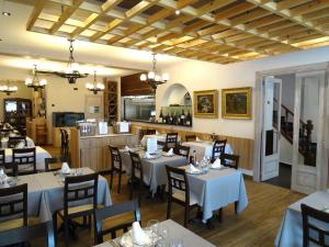 滨海托萨维多利亚酒店的一间带白色桌椅的餐厅和一间厨房