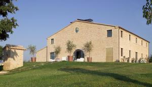 TrecastelliSolea Relais di Charme- Adults only的一座大型砖砌建筑,位于郁郁葱葱的绿地顶部