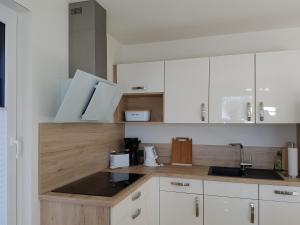于克里茨Hafenzauber的厨房配有白色橱柜和水槽