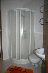 特热邦午睡旅馆的带淋浴、卫生间和盥洗盆的浴室