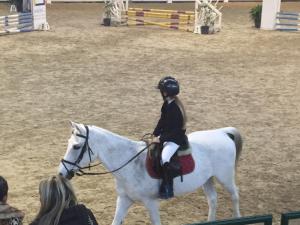 萨尔扎纳训马场酒店的一名儿童骑着白马
