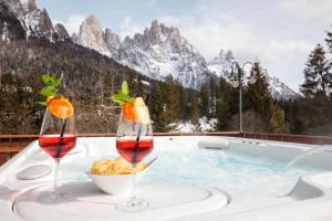 圣马蒂诺-迪卡斯特罗扎欧罗巴酒店的热水浴池,配有两杯葡萄酒和一碗食物