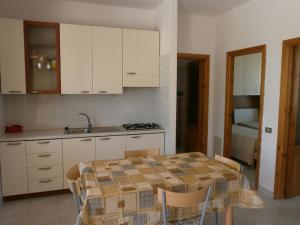 维耶斯泰Villa Grazia的厨房配有桌子、水槽和白色橱柜。