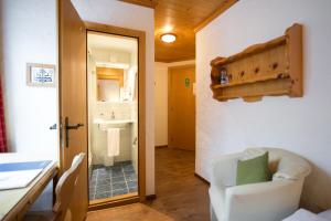 格施塔德维多利亚运动酒店的一间设有白色椅子和一间浴室的客房