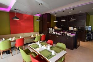 吉达哈亚特赫拉酒店的餐厅设有多彩的桌椅和柜台