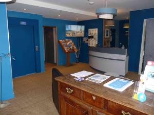 佩罗斯-吉雷克罗驰酒店的一间设有蓝色墙壁和书桌的柜台的房间