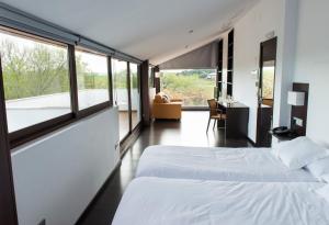 Villanueva del ReyHotel Rural Las Monteras的带大窗户的客房内的两张床