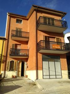泰拉诺瓦迪波利诺B&B Tufaro Alberico的红砖建筑,设有两个阳台和两个门