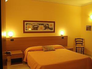 阿夸维瓦Il Piccolo Residence的酒店客房,设有床和黄色的墙壁
