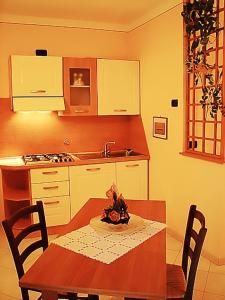 阿夸维瓦Il Piccolo Residence的带桌子的厨房和带水槽的厨房