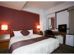 郡山郡山华盛顿酒店 的酒店客房设有一张大床和一张书桌。