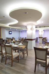 阿达纳森巴亚克市酒店的用餐室配有木桌和椅子