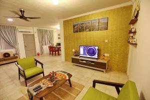 米里康明度假屋的客厅配有平面电视和绿色椅子。