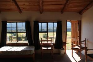 蒂阿瑙蒂阿瑙谷场背包客旅舍的卧室设有窗户、一张床和椅子