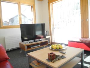 萨斯阿尔马格尔Adlerhorst的客厅配有电视和一张带一碗水果的桌子