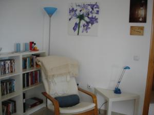 科斯塔巴伦娜科斯塔巴伦生活公寓的一间带椅子和书架的房间