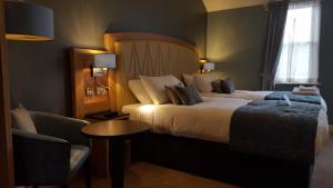 切斯特布尔&斯特拉普-维泽斯布恩酒店的酒店客房带一张大床和一把椅子