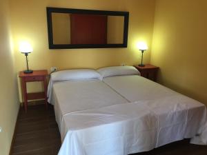 戈梅拉岛圣塞瓦斯蒂安Casa Reyes的一间卧室配有一张带两盏灯的大型白色床。