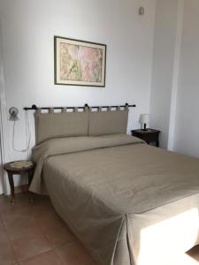 阿西亚罗利Residenza Le Serre的一间卧室配有一张大床和棕褐色床罩