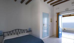帕纳雷阿Hotel Girasole的一间卧室设有一张床,一扇通往大海的门
