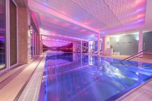盖洛斯施翁鲁酒店的紫色灯的房子里的一个游泳池