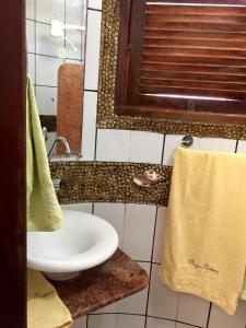 卡博迪圣阿戈斯蒂尼奥Pousada Acgua Residenz的浴室配有白色水槽和毛巾
