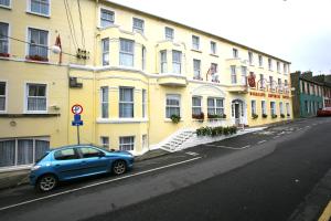 巴利香农多里安斯帝国酒店的停在黄色建筑前面的蓝色汽车