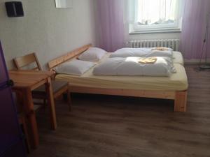 库罗阿尔滕堡奥斯特格比格酒店的一间卧室配有一张带两个枕头和一张桌子的床。